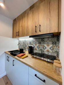 een keuken met houten kasten en een fornuis met oven bij Przytulne mieszkanie w centrum miasta in Radom