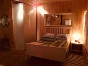 1 dormitorio con 1 cama en una pared de madera en Sidorówka nad Wigrami, en Krasnopol