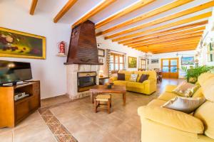 Elle comprend un salon doté d'un mobilier jaune et d'une cheminée. dans l'établissement Ideal Property Mallorca - Moli, à El Port