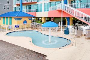 a pool with an umbrella in front of a building at Prince Resort Oceanfront 1834 at Cherry Grove Pier in Myrtle Beach