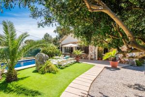 a garden with a swimming pool and a house at Ideal Property Mallorca - Villa Jardi in Alcudia