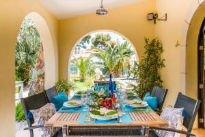 Ideal Property Mallorca - Villa Jardi في الكوذيا: غرفة طعام مع طاولة وكراسي