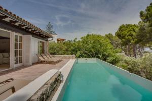einen Pool mit Terrasse und ein Haus in der Unterkunft Ideal Property Mallorca - Padri in Font de Sa Cala