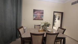 a dining room with a table and chairs and a painting at LUXURIOUS SEA VIEW APARTMENT FOR STAYS! in Ajman 
