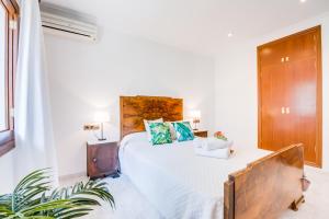ein Schlafzimmer mit einem großen Bett mit einem hölzernen Kopfteil in der Unterkunft Ideal Property Mallorca - Sa Dalia in Port d'Alcúdia