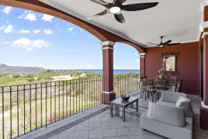 un portico con ventilatore a soffitto, tavolo e sedie di Bougainvillea 4315 PH- Luxury 3 Bedroom Ocean View Resort Condo a Brasilito