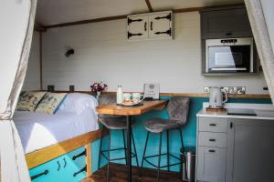 a bed in a tiny house with a small kitchen at Cwm Cariad in Knighton