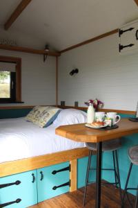 a bedroom with a bed and a wooden table at Cwm Cariad in Knighton