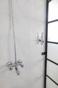 a shower in a bathroom with white tiles at Wild Amboseli Ndovu Cottage. in Amboseli +88 photos