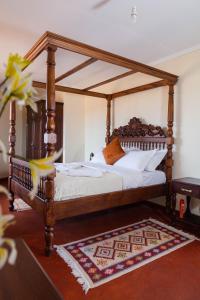 ein Bett mit einem Holzrahmen in einem Zimmer in der Unterkunft Wild Amboseli Ndovu Cottage. in Amboseli-Nationalpark