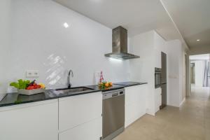 una cocina con armarios blancos y fregadero en Ideal Property Mallorca - Son Vent Muntanya - 1 en Sa Pobla