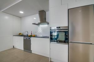 cocina con paredes blancas y electrodomésticos de acero inoxidable en Ideal Property Mallorca - Son Vent Muntanya - 1 en Sa Pobla