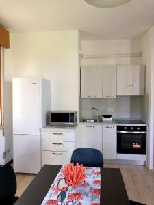 卡瓦利諾－特雷波爾蒂的住宿－BUNGALOW CAVALLINO LIDO，一间厨房,配有白色家电和一张桌子