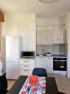 a kitchen with white appliances and a table in a room at BUNGALOW CAVALLINO LIDO in Cavallino-Treporti