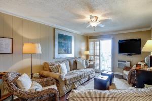 a living room with a couch and a tv at Beach Cottage at OD in Myrtle Beach