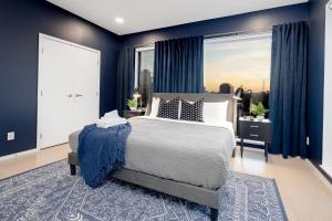 a bedroom with blue walls and a bed and a window at 700 1st Ave N Unit 507 in Nashville