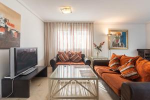 a living room with a couch and a tv at Guadalmina Baja in Marbella