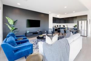 a living room with blue chairs and a tv at 700 1st Ave N Unit 507 in Nashville