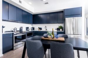 a kitchen with blue cabinets and a table with chairs at 700 1st Ave N Unit 507 in Nashville