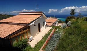 een huis op een heuvel met de oceaan op de achtergrond bij Residence Galati in Capo dʼOrlando