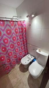 y baño con aseo y cortina de ducha. en Duplex Casnati en San Rafael