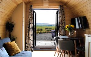 uma porta aberta para um quarto com uma mesa e cadeiras em Cwm Hapus em Knighton