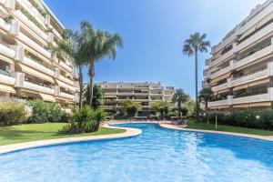 uma piscina em frente a um grande edifício de apartamentos em Guadalmina Alta em Marbella