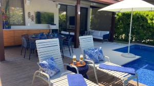 d'une terrasse avec une table et des chaises à côté de la piscine. dans l'établissement Bangalô Muro Alto Oka Beach Luxo, à Porto de Galinhas