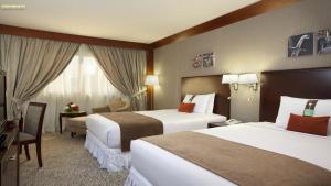 a hotel room with two beds and a television at Holiday Inn Al Khobar - Corniche by IHG in Al Khobar