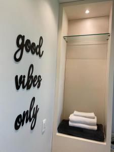 a bathroom with a sign that reads good vibes only at Apto Pé na Areia Condomínio Oceanside Camboinhas in Niterói
