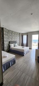 1 dormitorio con 2 camas y ventana grande en Down South 118 Beach Resort en Oslob
