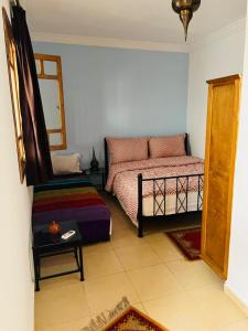 1 dormitorio con 1 cama y 1 silla en Hostel Amour d'auberge, en Marrakech