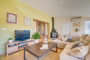 a living room with a couch and a tv at Ideal Property Mallorca - Binibonaire 2 PAX in Binissalem