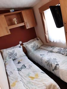 a small room with two beds and a window at BUTLINS SKEGNESS, 3 Beds, Pet Friendly - The Paddock in Lincolnshire