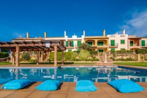 une villa avec une piscine en face d'un bâtiment dans l'établissement Blau Mari 2 PAX, à Sa Ràpita