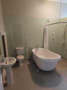 ein Badezimmer mit einer Badewanne, einem WC und einem Waschbecken in der Unterkunft Bank House in Thurso