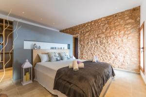 a bedroom with a bed and a stone wall at Ideal Property Mallorca - Pleta 8 PAX in Manacor