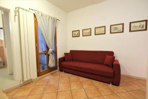 un divano rosso in un soggiorno con finestra di Wine Apartments Florence Dolcetto a Firenze