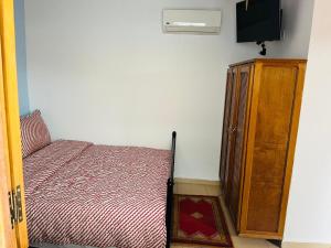 um quarto com uma cama e um armário de madeira em Hostel Amour d'auberge em Marrakech