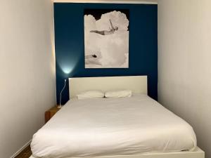 1 dormitorio con cama blanca y pared azul en Paz Apartment, en Lisboa