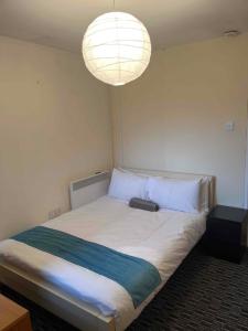 a bedroom with a large bed with a large light at Centralized Complete 3 BR Flat at Newcastle-Under-Lyme with a View-Free Parking in Newcastle under Lyme