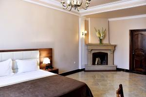 1 dormitorio con 1 cama y chimenea en Hotel Gremi Tbilisi, en Tiflis