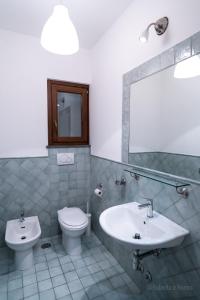 een badkamer met een wastafel, een toilet en een spiegel bij Orvieto Rocca Fiorita in Orvieto