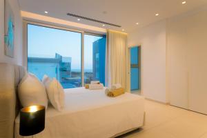 a bedroom with a bed with a large window at Cove Seaview Villas - Neptune in Ayia Napa