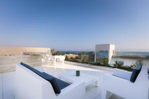 a balcony with white furniture on top of a building at Cove Seaview Villas - Neptune in Ayia Napa