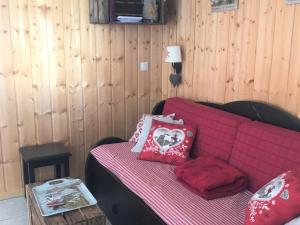 a red couch with pillows on it in a room at Chalet rénové 6 pers, TV connectée, WiFi, parking, animaux admis - FR-1-504-480 in Le Dévoluy