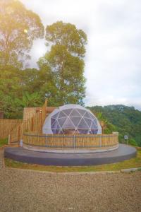 a building with a glass dome in a garden at Skypruek Luu Hlee ลุฮลี in Mon Jam