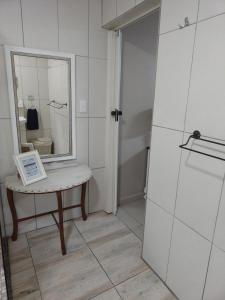 a bathroom with a table with a mirror on it at Dollies place in Bazley Beach
