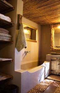 a bathroom with a bath tub and a sink at Mogalakwena River Lodge in Alldays