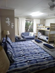 Dollies place في Bazley Beach: غرفة نوم مع سرير وغرفة معيشة